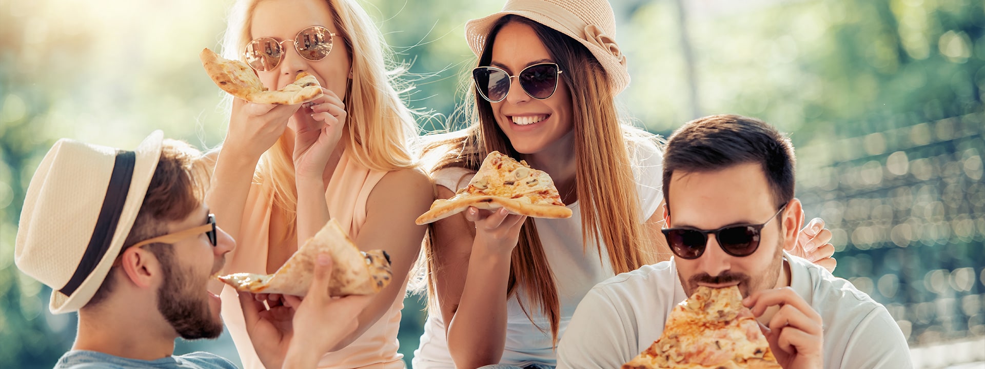 Giovani che ridono e mangiano la pizza